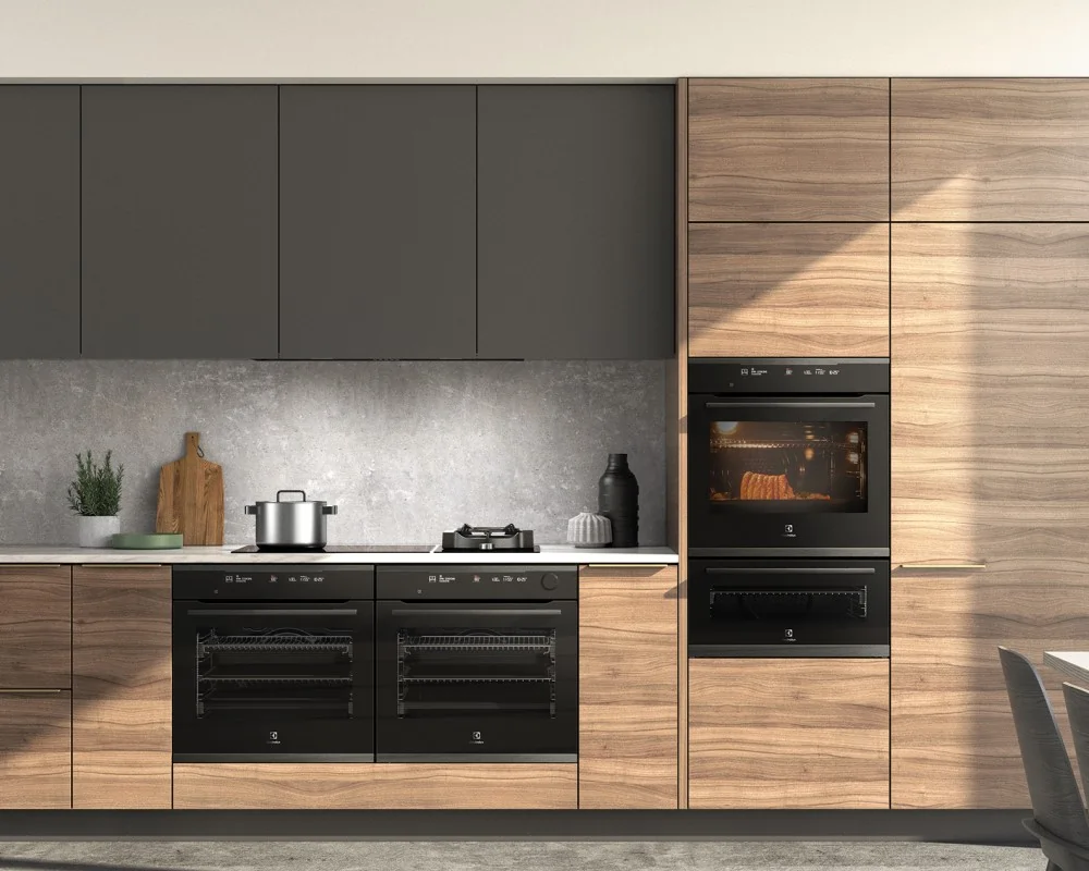 A modern kitchen featuring built-in Electrolux ovens and a cooktop integrated into wood and matte-grey cabinetry, with a stone backsplash and minimal decor.