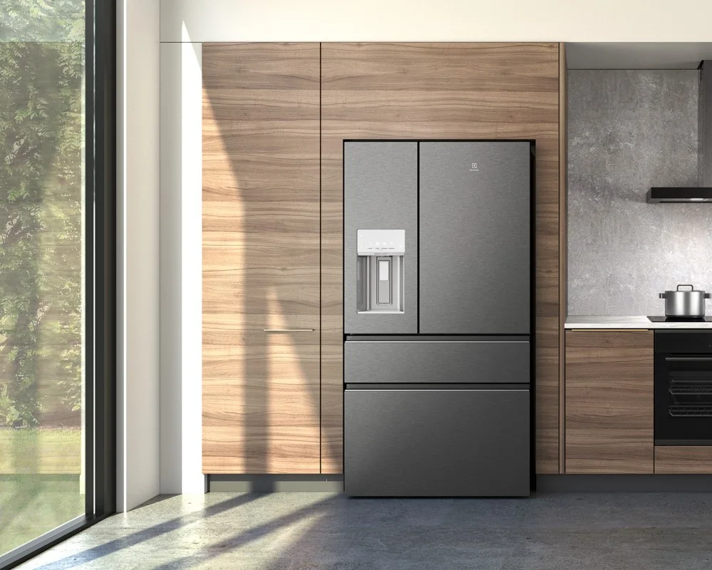 A modern kitchen with wood cabinetry featuring a stainless steel Electrolux French-door refrigerator with an external water and ice dispenser.